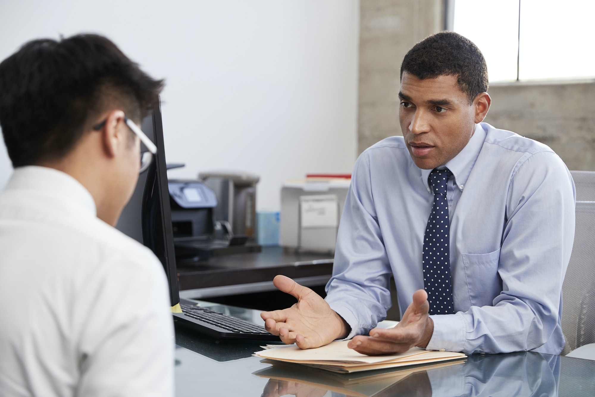 Concerned mixed race male therapist counselling male patient