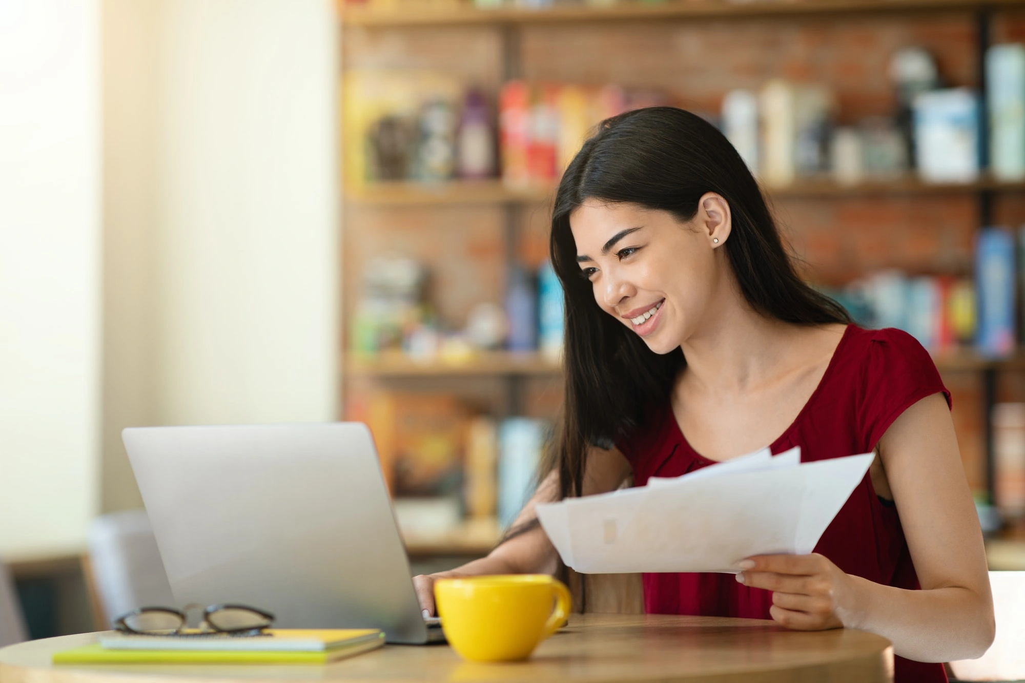 young asian businesswoman checking financial reports and working on laptop in cafe.jpg